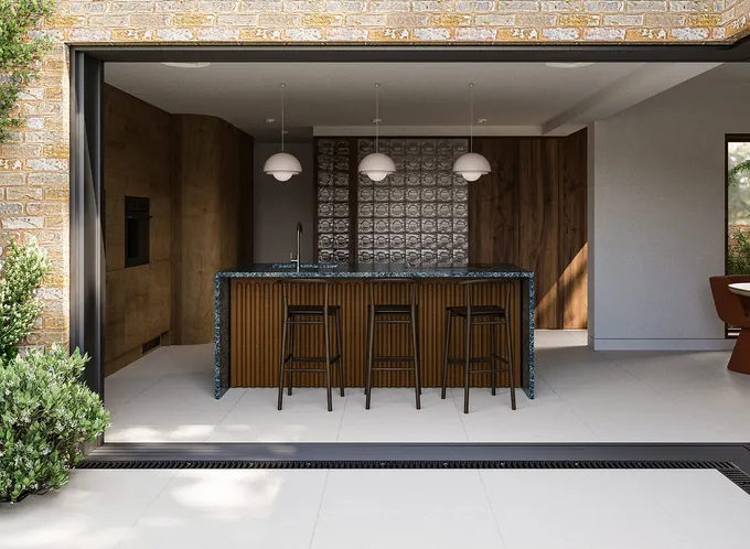 Skala Studio's visionary design is showcased in this image, highlighting a striking green stone kitchen island with a terracotta backdrop, wooden panels in varying shades cladding the internal walls, and an alluring glass block wall. A window provides glimpses of the verdant garden beyond.